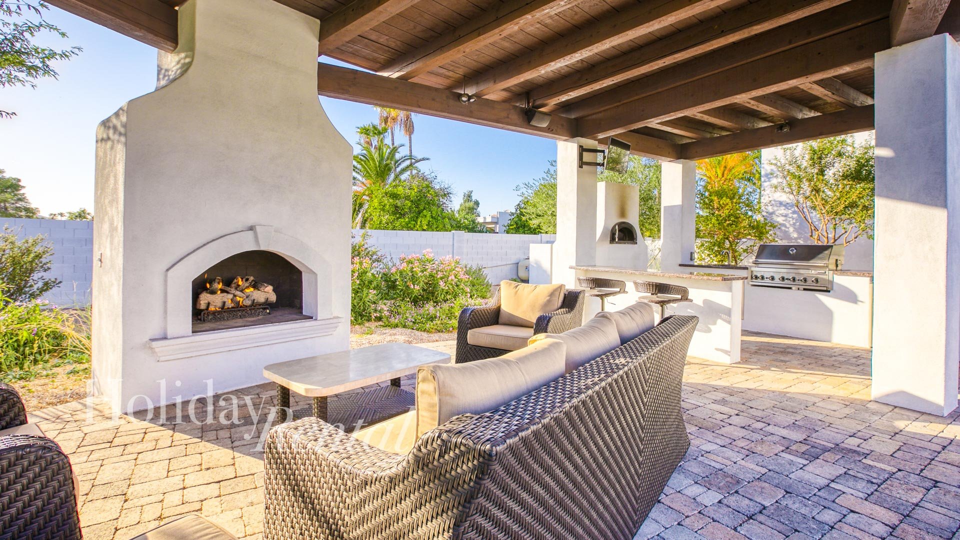 Covered seating area with outdoor fireplace and built-in grill