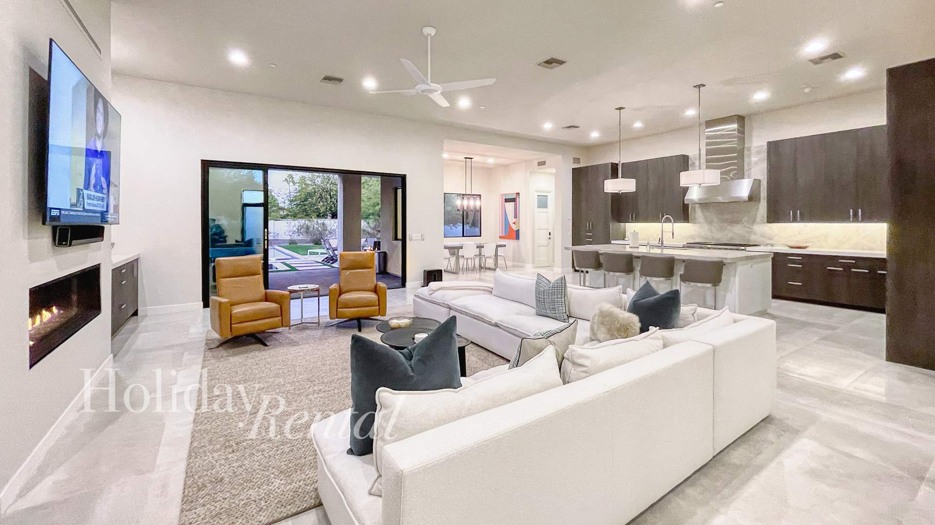 A spacious and inviting living room, complete with comfortable couches and a large TV for movie nights, and a modern kitchen with a generous island for cooking and entertaining. Step outside and into 