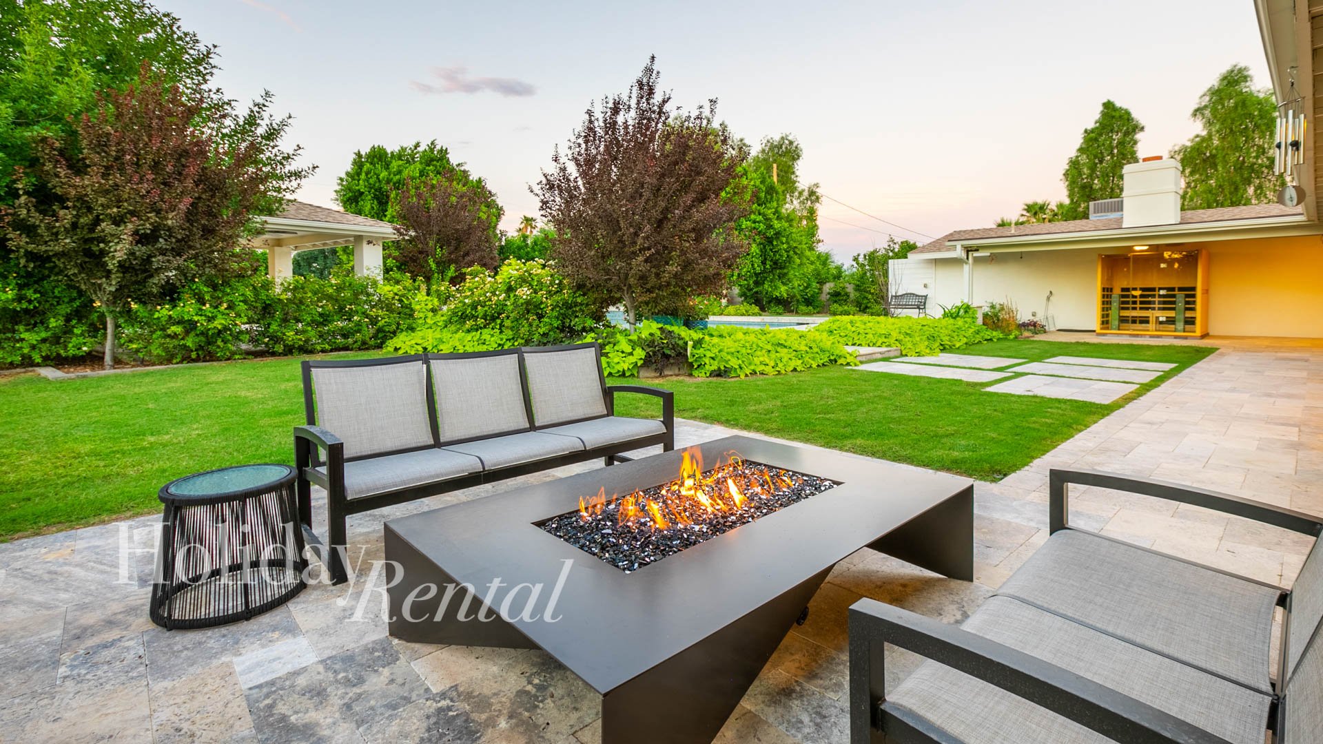 Plenty of room for all to gather and relax on the luxurious backyard patio, complete with an outdoor TV, fire pit, and protected from the elements by an overhang