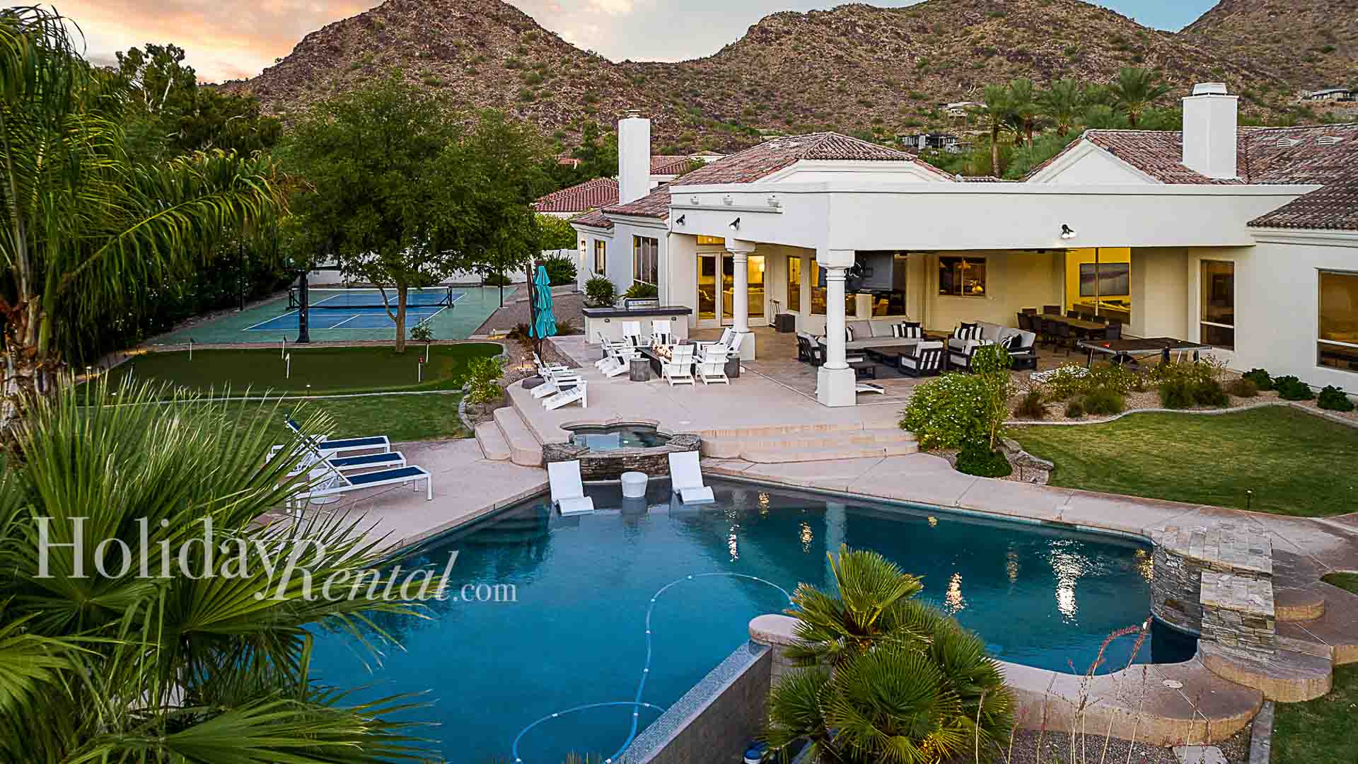 Large entertainment backyard w/ loungers, pool, spa, firepit, and games.